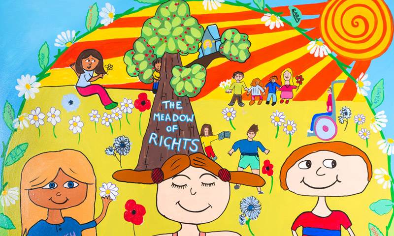 A mural shows children sitting in "the meadow of rights"