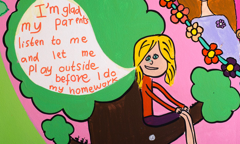 Child sitting in a tree with a speech bubble reading "I'm glad my parents listen to me and let me play outside before I do my homework"