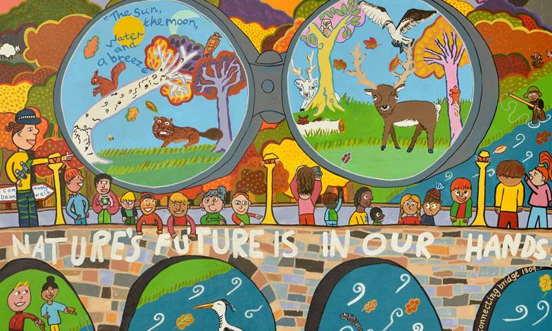 A mural shows children walking across a bridge. A banner reads "Nature's Future is in Our Hands". The mural was painted by Members of Children's Parliament.