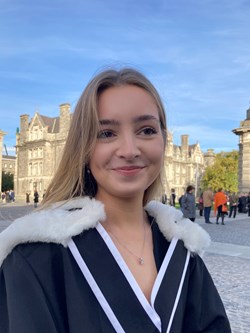 Photo of Judi smiling wearing her graduation robes.
