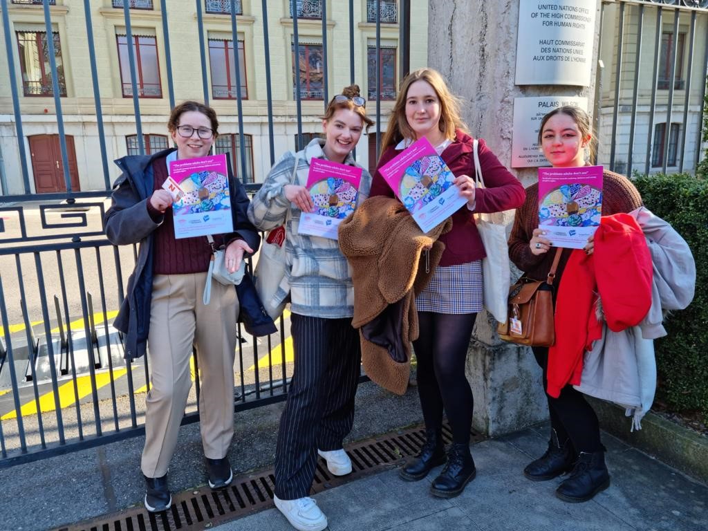 Photo shows right to left Arden MCP, Beau MSYP, Daisy MSYP and Omima MCP holding copies of their report to the UN Committee on the Rights of the Child outside the gates of Palais Wilson, Geneva.