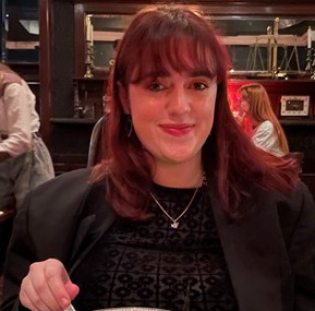 Photo of Isobel smiling in a restaurant.