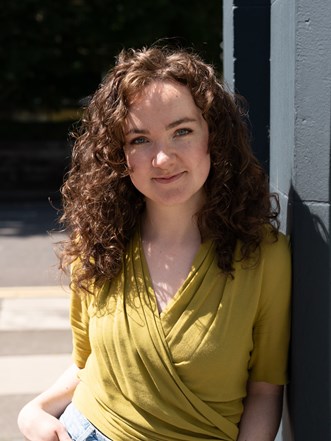 Maria leaning against a wall