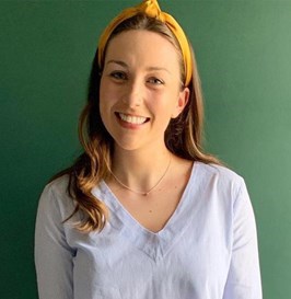 Photo of Helen wearing a yellow headband with a green background.