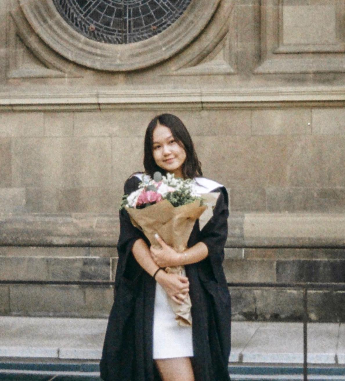 Photo of Christina at graduation holding flowers